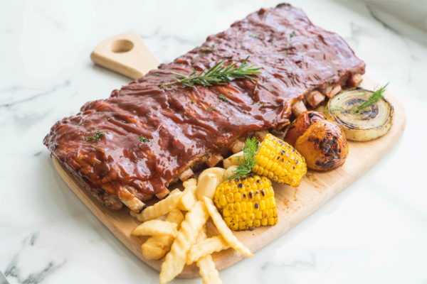 grilled rib pork with barbecue sauce vegetable frech fries wooden cutting board